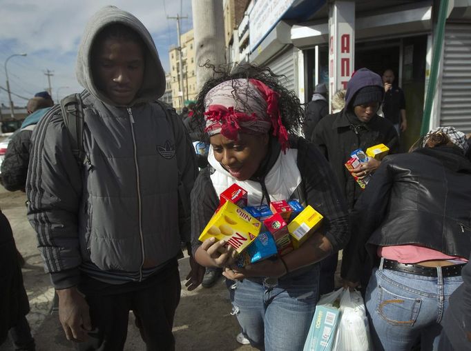 People scramble for food and supplies being handed outside a grocery store damaged by Hurricane Sandy in the Rockaways section of the Queens borough of New York November 1, 2012. New York power company Consolidated Edison Inc said Thursday it still had about 659,400 homes and businesses without power three days after monster storm Sandy slammed into the U.S. East Coast. REUTERS/Shannon Stapleton (UNITED STATES - Tags: ENVIRONMENT DISASTER) Published: Lis. 1, 2012, 4:15 odp.