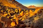 Úpatí kopce "cukrová homole" Sugarloaf v západní Namibii a bezejmenný masiv vzadu na horizontu. Grosse Spitzkoppe je napravo, mimo záběr.