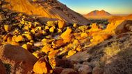Úpatí kopce "cukrová homole" Sugarloaf v západní Namibii a bezejmenný masiv vzadu na horizontu. Grosse Spitzkoppe je napravo, mimo záběr.