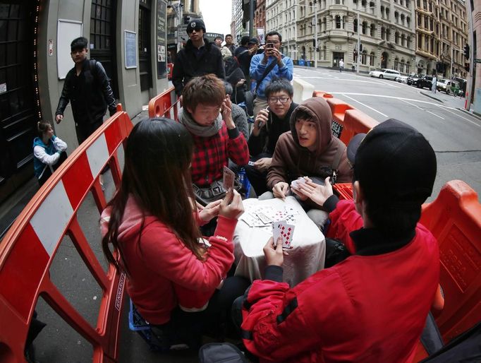 People play card games as they queue outside an Apple store and wait to buy an iPhone 5, in central Sydney September 21, 2012. Apple Inc's iPhone 5 hit stores around the globe on Friday, with fans snapping up the device that is expected to fuel a huge holiday quarter for the consumer giant. REUTERS/Tim Wimborne (AUSTRALIA - Tags: BUSINESS SCIENCE TECHNOLOGY TELECOMS) Published: Zář. 20, 2012, 11:19 odp.