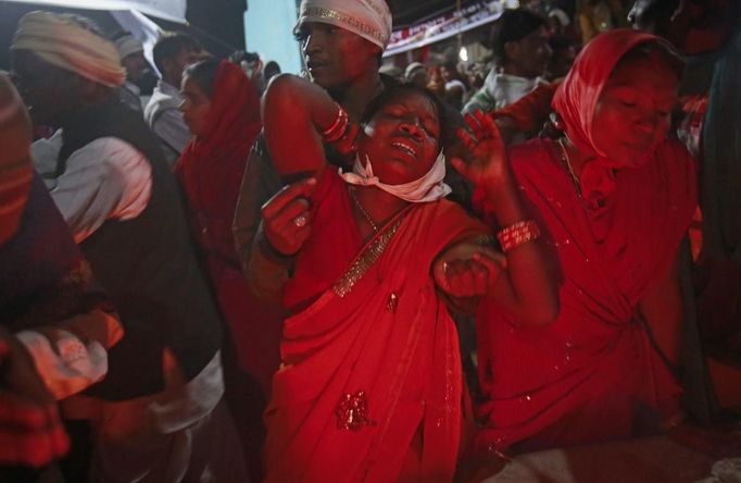 A man holds a devotee who is believed to be possessed by evil spirits as she goes into a state of trance at Guru Deoji Maharaj temple during a ghost fair at Malajpur village in Betul district in the central Indian state of Madhya Pradesh January 26, 2013. People from across India come to this fair to be exorcised of �evil spirits�. They are usually brought by relatives and they are most often women. The exorcism involves running around the temple courtyard to make the 'ghost' weak then being beaten by a priest with a broom. Picture taken January 26, 2013. REUTERS/Danish Siddiqui (INDIA - Tags: SOCIETY RELIGION) ATTENTION EDITORS: PICTURE 22 OF 24 FOR PACKAGE 'INDIAN GHOSTBUSTERS' SEARCH 'INDIA GHOST' FOR ALL IMAGES Published: Úno. 5, 2013, 5:10 dop.