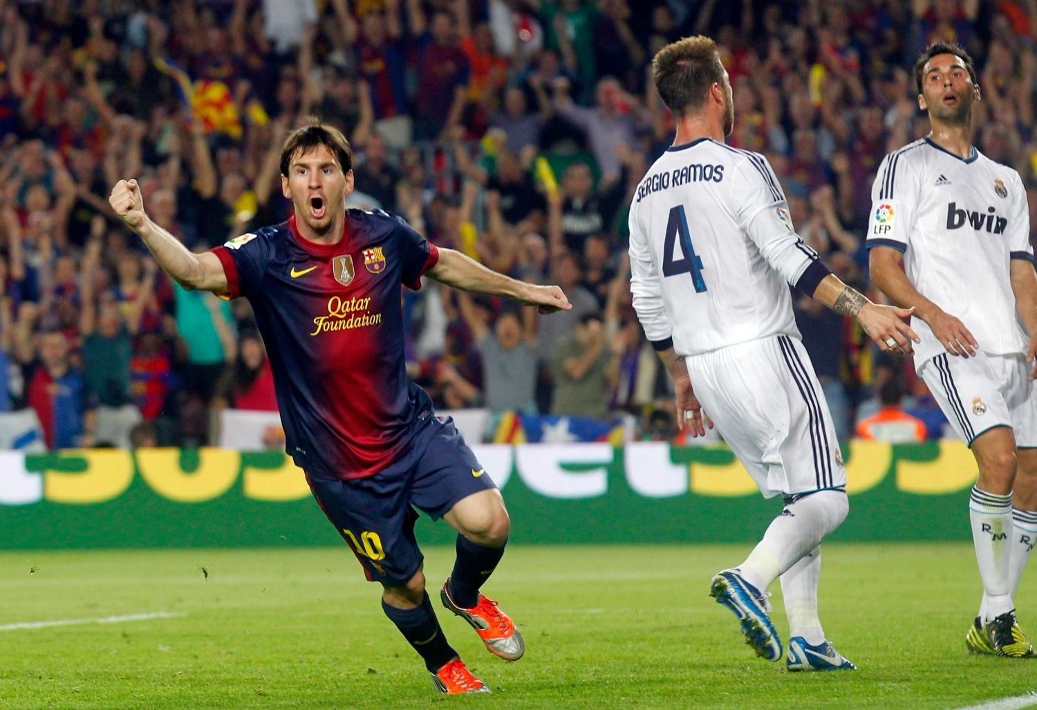 Fotbalista Barcelony Lionel Messi (vlevo) slaví gól za zády Sergia Ramose a Alvara Arbeloy v utkání Primera División proti Realu Madrid.