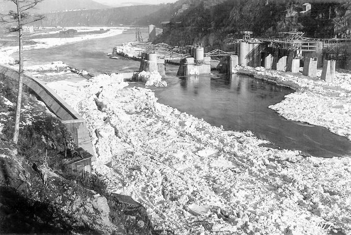 Historická fotografie zachycující výstavbu vodní nádrže Štěchovice, která probíhala mezi lety 1937 a 1944, navzdory válečným komplikacím.