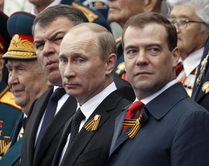 Russian President Vladimir Putin (C), Prime Minister Dmitry Medvedev (R) and acting Defence Minister Anatoly Serdyukov (2nd L) watch the Victory Parade on Moscow's Red Square May 9, 2012. Russia celebrates the 67th anniversary of the victory over Nazi Germany on Wednesday. REUTERS/Sergei Karpukhin (RUSSIA - Tags: POLITICS ANNIVERSARY MILITARY) Published: Kvě. 9, 2012, 7:57 dop.