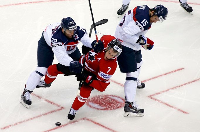 Slovakia's Karol Sloboda (L) and Marek Hrivik (R) knock Canada's Kyle Turris (C) during the first period of their men's ice hockey World Championship group A game at Chiz