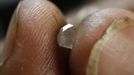 A diamond cutter shows a rough stone while working on it in his work place in Santa Elena de Uairen in the south of Venezuela November 12, 2012. In the triangle that connects Venezuela, Brazil and Guyana a huge number of illegal gold and diamonds prospectors or garimpeiros dream of changing their lives overnight by finding a huge bonanza. Picture taken November 12, 2012. REUTERS/Jorge Silva (VENEZUELA - Tags: BUSINESS SOCIETY COMMODITIES TPX IMAGES OF THE DAY) ATTENTION EDITORS: PICTURE 17 OF 20 FOR PACKAGE 'DIAMONDS IN THE JUNGLE'. TO FIND ALL IMAGES SEARCH 'DIAMONDS PROSPECTORS' Published: Pro. 3, 2012, 10:04 dop.