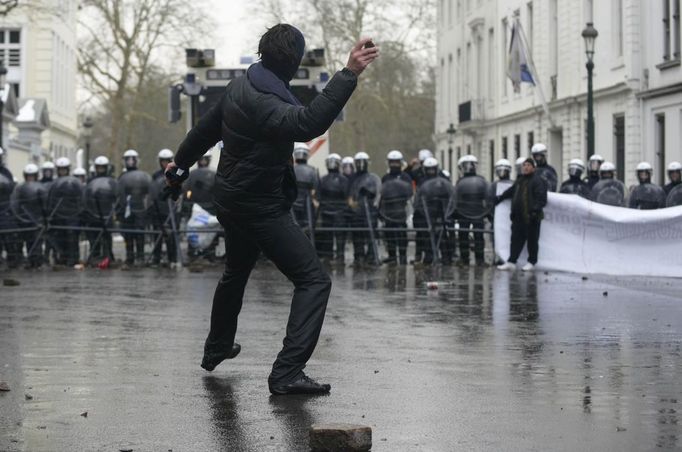 ¨ An Arcelor Mittal worker from Liege throws a stone during a demonstration outside Prime Minister Elio Di Rupo's office, where a political meeting is taking place, in Brussels January 25, 2013. ArcelorMittal, the world's largest steel producer, plans to shut a coke plant and six finishing lines at its site in Liege Belgium, affecting 1,300 employees, the group said on Thursday. REUTERS/Yves Herman (BELGIUM - Tags: BUSINESS CIVIL UNREST EMPLOYMENT) Published: Led. 25, 2013, 2:42 odp.