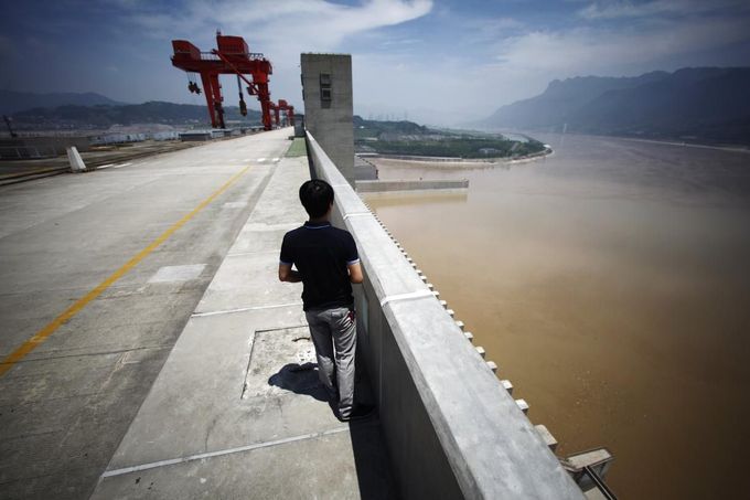 A man stands on the Three Gorges dam in Yichang, Hubei province in this August 9, 2012 file photo. China relocated 1.3 million people during the 17 years it took to complete the Three Gorges dam. Even after finishing the $59 billion project last month, the threat of landslides along the dam's banks will force tens of thousands to move again. It's a reminder of the social and environmental challenges that have dogged the world's largest hydroelectric project. While there has been little protest among residents who will be relocated a second time, the environmental fallout over other big investments in China has become a hot-button issue ahead of a leadership transition this year. Picture taken on August 9, 2012. To match story CHINA-THREEGORGES/ REUTERS/Carlos Barria/Files (CHINA - Tags: POLITICS ENVIRONMENT BUSINESS ENERGY) Published: Srp. 22, 2012, 8:40 odp.