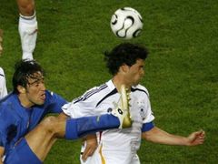 Ital Luca Toni (v modrém) v ostrém souboji s Michaelem Ballackem z Německa.