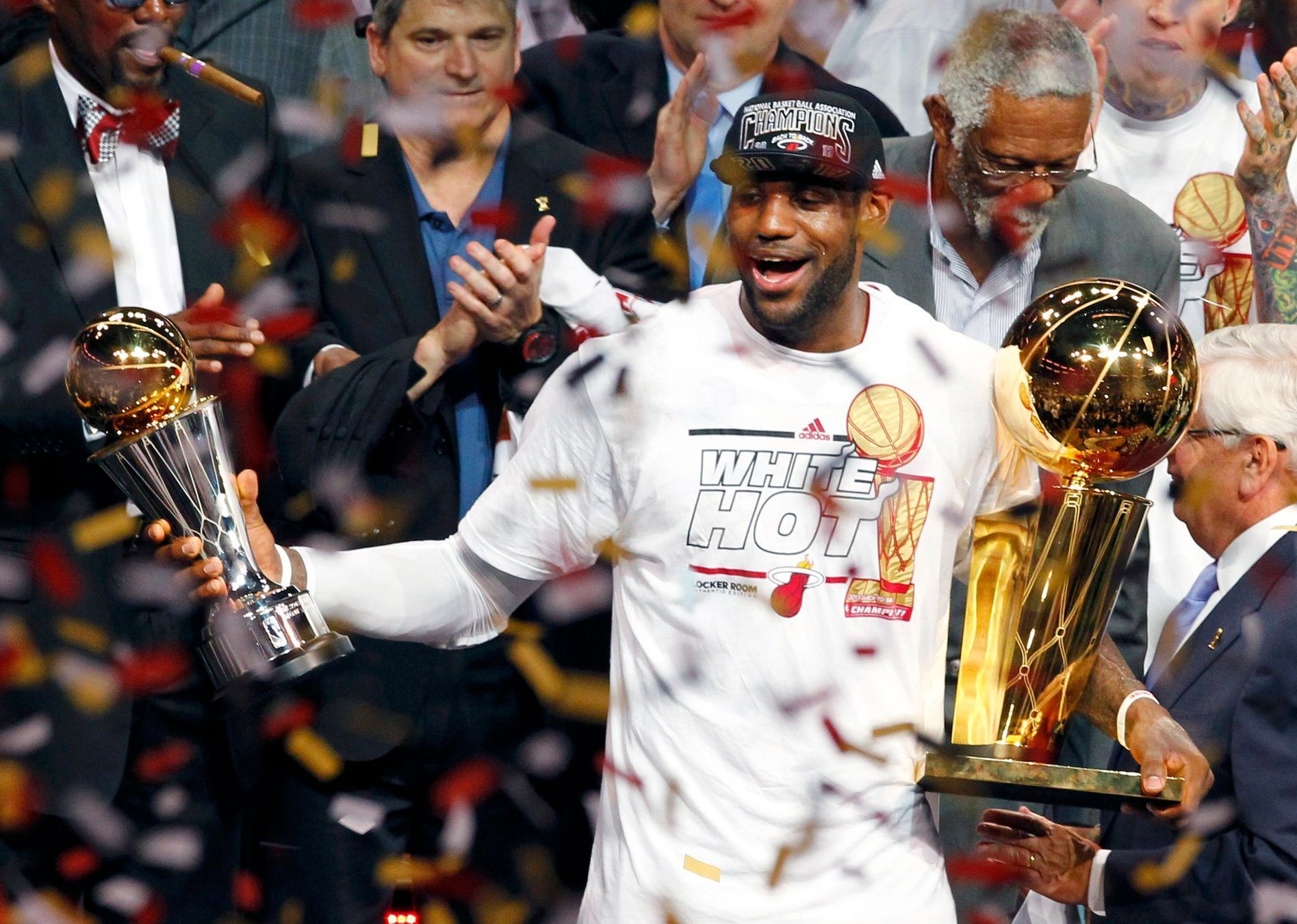 Miami Heat's James holds the Larry O'Brien Trophy and the Bi