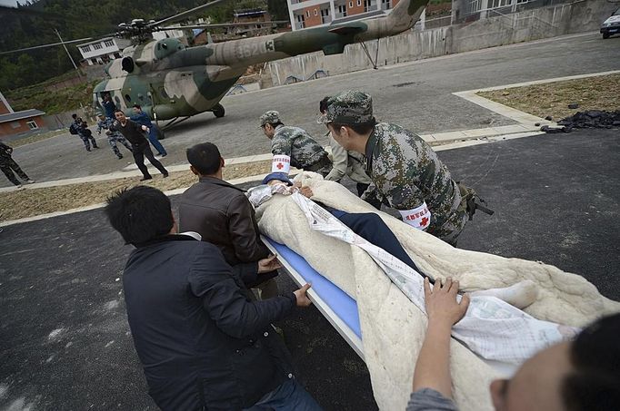 Rescuers rush to carry a victim onto a helicopter after a strong 6.6 magnitude earthquake hit Taiping town of Lushan county, Sichuan province April 20, 2013. Rescuers poured into a remote corner of southwestern China on Sunday as the death toll from the country's worst earthquake in three years climbed to 164 with more than 6,700 injured, state media said. The 6.6 magnitude quake struck in Lushan county, near the city of Ya'an in the southwestern province of Sichuan, at a depth of 12 km (7.5 miles), close to where a devastating 7.9 temblor hit in May 2008 killing some 70,000. Picture taken April 20, 2013. REUTERS/Stringer (CHINA) Published: Dub. 21, 2013, 2:10 dop.