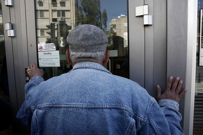 Čekající klient před vstupem do Laiki Bank v Nikósii.