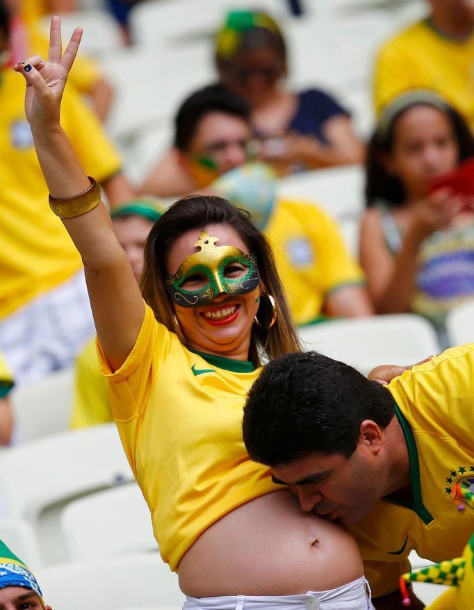 A fan of Brazil kisses the stomach of a fellow fan before their 2014 World Cup Group A soccer match against Mexico at the Castelao arena in Fortaleza June 17, 2014. REUTE