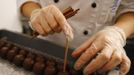 A confectioner produces original Salzburger Mozartkugeln pralines in the confectionery 'Fuerst' in the Austrian city of Salzburg October 19, 2012. The confectionery Fuerst invented the original Salzburger Mozartskugeln, named after the famous composer Wolfgang Amadeus Mozart, in 1884 and still produces 2.5 million Mozartskugeln pralines per year exclusively by hand. REUTERS/Dominic Ebenbichler (AUSTRIA - Tags: FOOD SOCIETY) Published: Říj. 19, 2012, 3:31 odp.