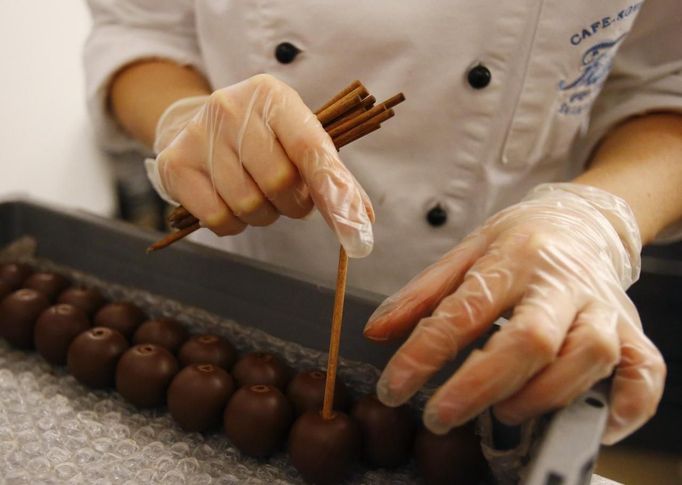 A confectioner produces original Salzburger Mozartkugeln pralines in the confectionery 'Fuerst' in the Austrian city of Salzburg October 19, 2012. The confectionery Fuerst invented the original Salzburger Mozartskugeln, named after the famous composer Wolfgang Amadeus Mozart, in 1884 and still produces 2.5 million Mozartskugeln pralines per year exclusively by hand. REUTERS/Dominic Ebenbichler (AUSTRIA - Tags: FOOD SOCIETY) Published: Říj. 19, 2012, 3:31 odp.