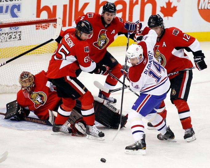 Tomáše Plekanec hrající za Montreal Canadiens bojuje o kotouč v souboji s hráči Ottawa Senators (zleva doprava brankář Mike Brodeur, dále Erik Karlsson, Chris Phillips a Mike Fisher).