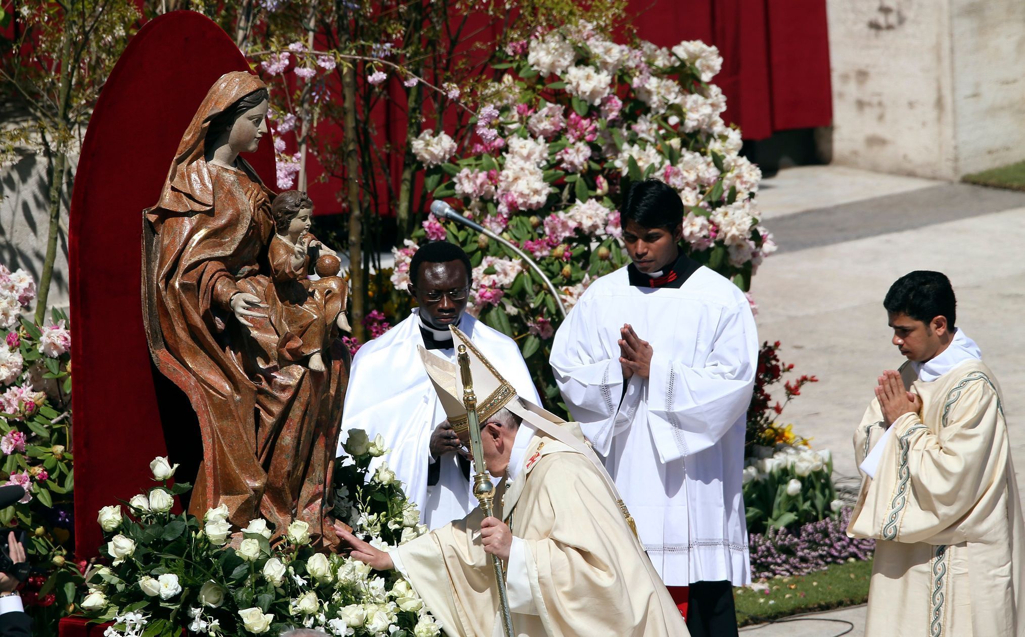 Pope Francis touches a statue of Virgin Mary as he leads the Easter mass in Saint Peter's Square at the Vatican