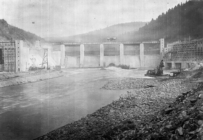 Historická fotografie zachycující výstavbu vodní nádrže Štěchovice, která probíhala mezi lety 1937 a 1944, navzdory válečným komplikacím.