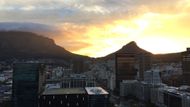 A pokud potom na jednu z výškových budov vystoupáte, může se vám naskytnout pohled na takovýto západ slunce. Vpravo Lions Head, vlevo Table mountain.