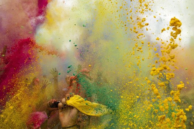 People throw coloured powder in the air during Holi festival celebrations in Berlin, July 29, 2012. Holi, also known as the festival of colours, is a festival celebrated in India and other Hindu countries that in its original form heralds the beginning of spring. The Berlin event brought Indian Djs, acrobatics and dance to the German capital. REUTERS/Thomas Peter (GERMANY - Tags: SOCIETY) Published: Čec. 29, 2012, 3:24 odp.