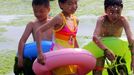 A group of Chinese children play at an algae covered public beach in Qingdao, northeast China's Shandong province on July 4, 2013. The seas off China have been hit by their largest ever growth of algae, ocean officials said, with vast waves of green growth washing onto the shores of the Yellow Sea. CHINA OUT AFP PHOTO Přidat do lightboxu Stáhnout náhled Odeslat emailem