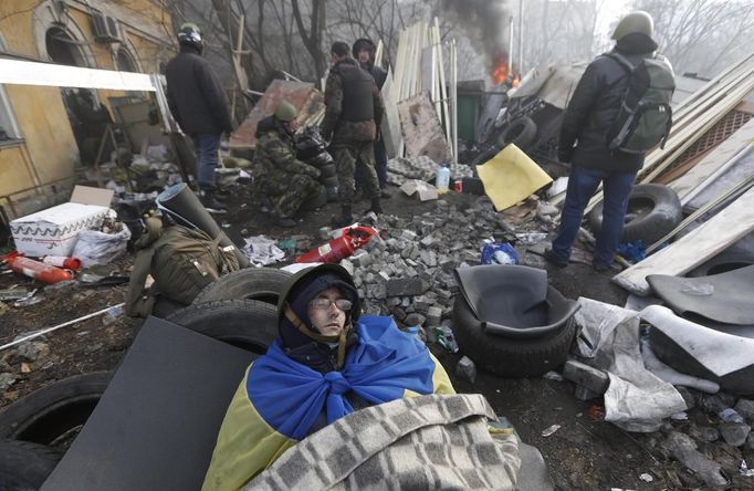 An anti-government protester rests at a barricade in Kiev February 21, 2014.