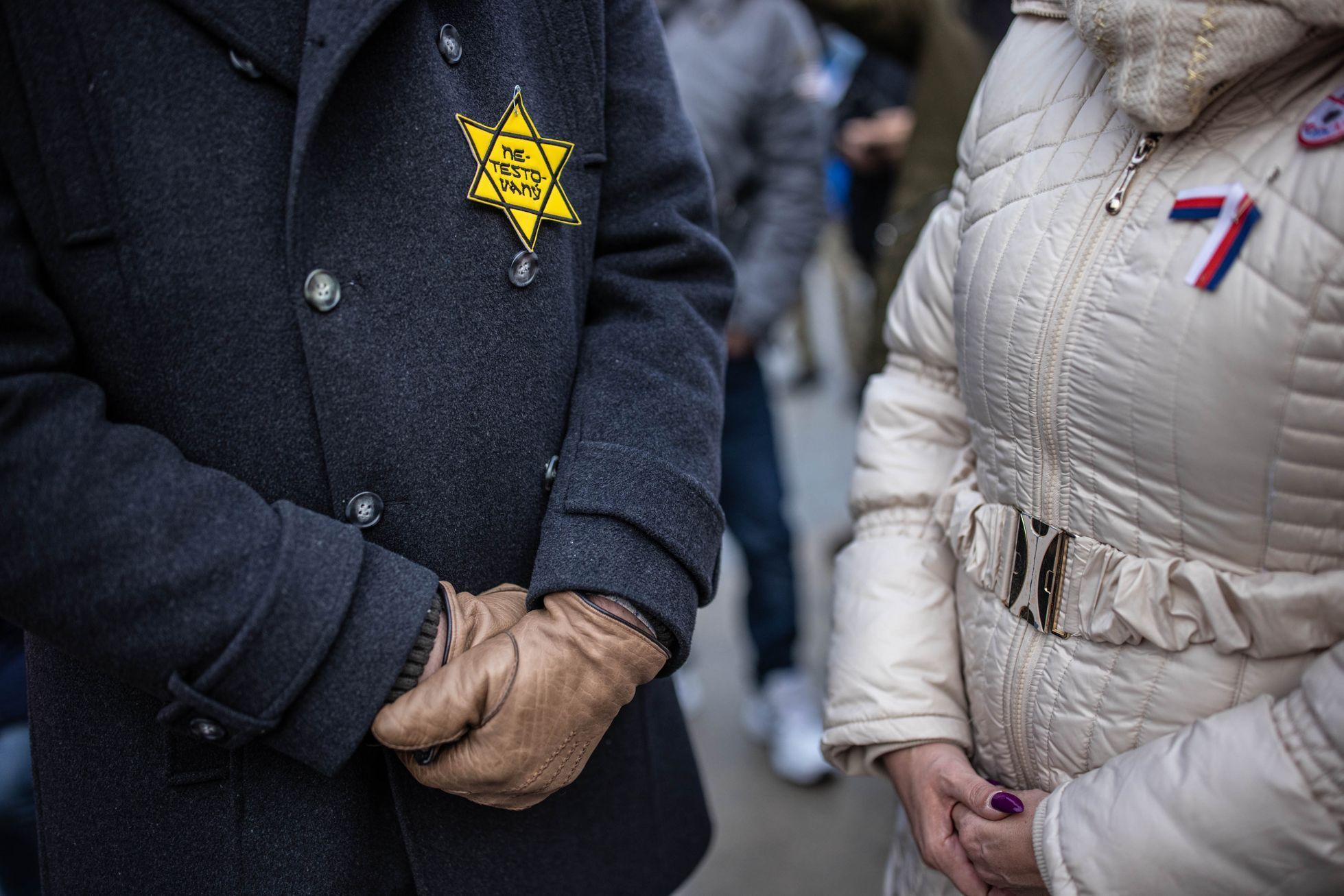 Lidé s připnutou židovskou hvězdou na demonstraci proti očkování