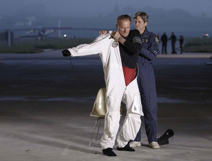 Solar Impulse project CEO and pilot Andre Borschberg puts on his suit before take off at Payerne airport May 24, 2012. The Solar Impulse HB-SIA prototype aircraft, which has 12,000 solar cells built into its 64.3 metres (193 feet) wings, attempted its first intercontinental flight from Payerne to Rabat in Morocco with a few days for a technical stop and a change of pilot in Madrid. This flight will act as a final rehearsal for the 2014 round-the-world flight. REUTERS/Denis Balibouse (SWITZERLAND - Tags: TRANSPORT SCIENCE TECHNOLOGY SOCIETY BUSINESS) Published: Kvě. 24, 2012, 8:10 dop.