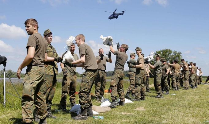 German Bundeswehr armed forces soldiers carry sandbags on a damaged dyke at the river Elbe at the village of Hohengoehren, north of Magdeburg June 10, 2013. Tens of thousands of people have been forced to leave their homes and there have been at least a dozen deaths as a result of floods that have hit Germany, Austria, Slovakia, Poland and the Czech Republic over the past week. REUTERS/Fabrizio Bensch (GERMANY - Tags: DISASTER ENVIRONMENT)