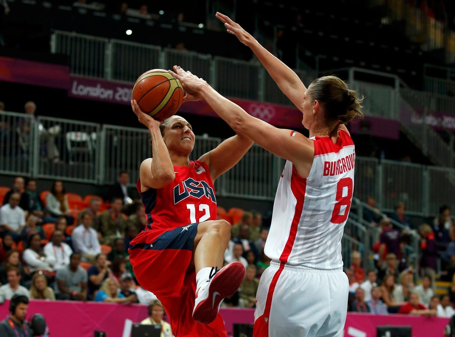 Česká basketbalistka Ilona Burgrová brání ve střelbě Američance Dianě Taurasiové v utkání skupiny A na OH 2012 v Londýně.