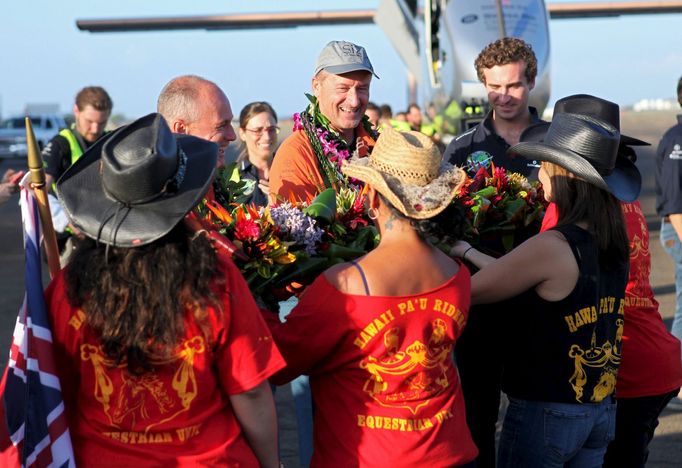 Pilot André Borschberg je po 120 hodinách ve vzduchu vítán na Havaji tradičním květinovým věncem.