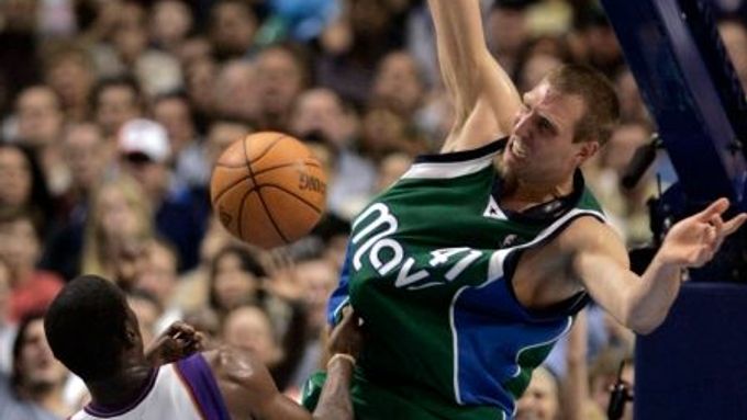 Hvězda Dallasu Dirk Nowitzki smečuje přes Amare Stoudemirea z Phoenix Suns.