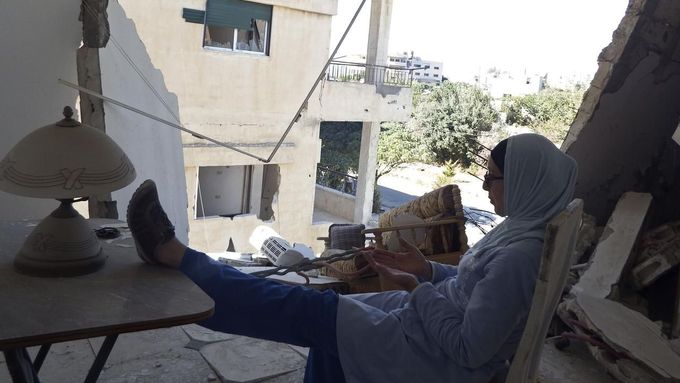 Lékařka sedí uvnitř zničené místnosti v domě v severozápadní Sýrii.