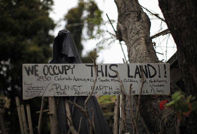 A protest sign is seen outside a trailer home in Village Trailer Park in Santa Monica, California July 12, 2012. Developer Marc Luzzatto wants to relocate residents from the trailer park to make way for nearly 500 residences, office space, stores, cafes and yoga studios, close to where a light rail line is being built to connect downtown Los Angeles to the ocean. Village Trailer Park was built in 1951, and 90 percent of its residents are elderly, disabled or both, according to the Legal Aid Society. Many have lived there for decades in old trailers which they bought. The property is valued at as much as $30 million, according the LA Times. Picture taken July 12, 2012. REUTERS/Lucy Nicholson (UNITED STATES - Tags: POLITICS REAL ESTATE BUSINESS SOCIETY TPX IMAGES OF THE DAY) Published: Čec. 14, 2012, 6:57 dop.