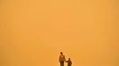 A Chinese woman and her child walk along a street during a sandstorm in Lanzhou, north China's Gansu province on April 23, 2009. Air pollution in China's cities remains very serious, state media quoted a minister as saying, amid an ongoing battle to clean up the skies in the world's largest coal-consuming nation. AFP PHOTO