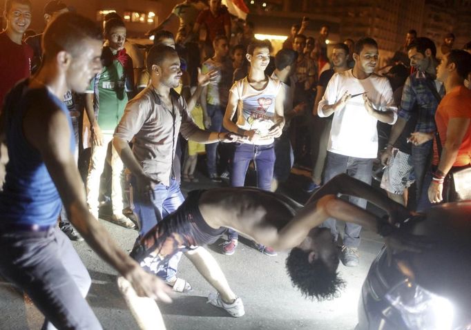 Anti-Mursi protesters dance in front of cars on a bridge near Tahrir square as people celebrate after the announcement of the removal from office of Egypt's deposed President Mohamed Mursi in Cairo, July 4, 2013. Mursi, toppled by the military on Wednesday, is being held by the authorities, a Muslim Brotherhood spokesman and a security official said on Thursday. REUTERS/Asmaa Waguih (EGYPT - Tags: POLITICS CIVIL UNREST) Published: Čec. 4, 2013, 12:38 dop.