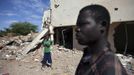 Douentza residents Hamidou Dicko (L) and Ousmane Togo survey the remains of a hotel in Douentza January 29, 2013. The hotel was used as a base for Islamists and was hit by French air strikes over a week ago. REUTERS/Joe Penney (MALI - Tags: CIVIL UNREST POLITICS CONFLICT) Published: Led. 29, 2013, 2:10 odp.