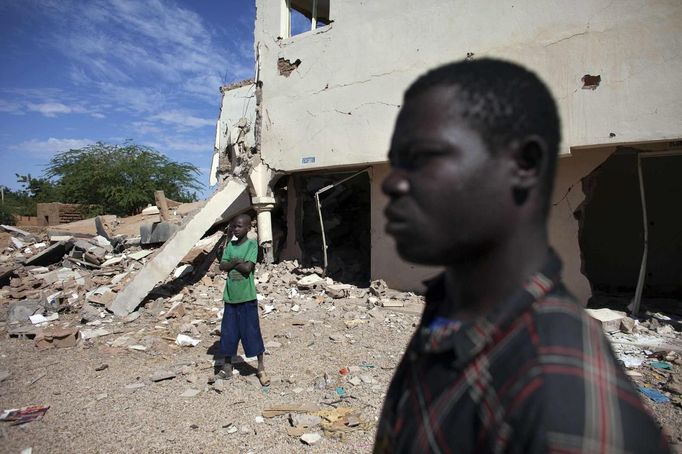 Douentza residents Hamidou Dicko (L) and Ousmane Togo survey the remains of a hotel in Douentza January 29, 2013. The hotel was used as a base for Islamists and was hit by French air strikes over a week ago. REUTERS/Joe Penney (MALI - Tags: CIVIL UNREST POLITICS CONFLICT) Published: Led. 29, 2013, 2:10 odp.