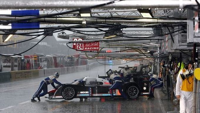 Mechanici tlačí do boxů jeden ze dvou Peugeotů 908 při kvalifikaci na 24 hodin v Le Mans.
