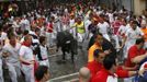 Runners sprint alongside a Dolores Aguirre fighting bull at the Telefonica corner during the first running of the bulls of the San Fermin festival in Pamplona July 7, 2012. One person was gored and four others injured in a run that lasted two minutes and fifty-two seconds, according to local media. REUTERS/Joseba Etxaburu (SPAIN - Tags: SOCIETY ANIMALS) Published: Čec. 7, 2012, 9:13 dop.