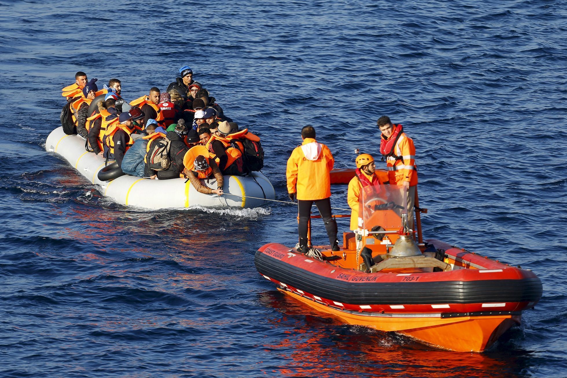 Turecká pobřežní stráž táhne člun s běženci.