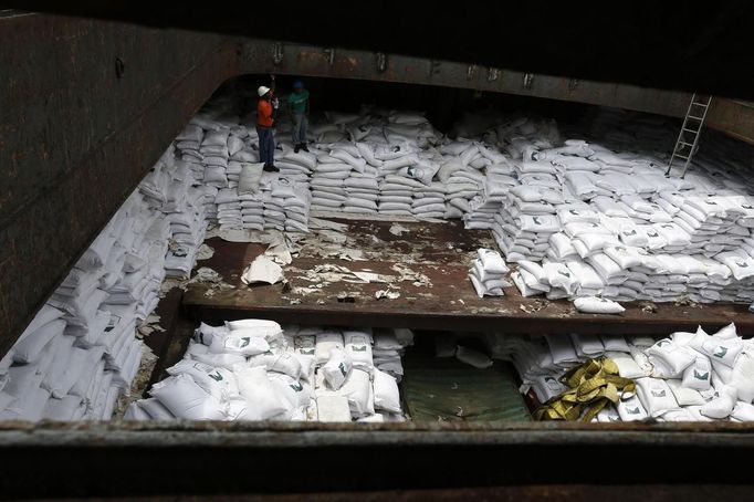 Worker stand on top of bags labeled "Cuban Raw Sugar" inside a North Korean flagged ship "Chong Chon Gang" docked at the Manzanillo Container Terminal in Colon City July 16, 2013. Panama detained the North Korean-flagged ship from Cuba as it headed to the Panama Canal and said it was hiding weapons in brown sugar containers, sparking a standoff in which the ship's captain attempted to commit suicide. Panama's President Ricardo Martinelli said the undeclared weapons were detected inside the containers when Panamanian authorities stopped the ship, suspecting it was carrying drugs. REUTERS/Carlos Jasso (PANAMA - Tags: CRIME LAW DRUGS SOCIETY POLITICS) Published: Čec. 16, 2013, 9:55 odp.