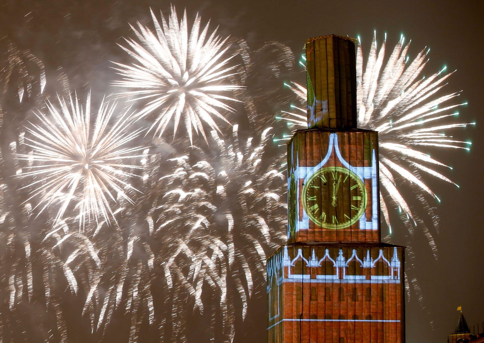 Fireworks light the sky over the Kremlin's Spasskaya Tower, covered by scaffolding, during celebrations of New Year's Day in Red Square in Moscow