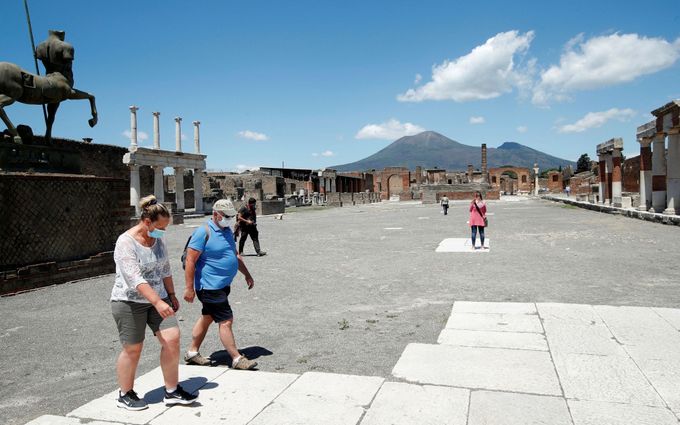 Turisté s ochrannými maskami v italských Pompejí v době koronaviru