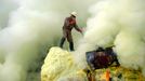 To go with story Indonesia-volcano-mine by Jerome Rivet A picture taken on March 8, 2010 shows Indonesian sulphur miner collecting sulphur surrounded by thick toxic smoke