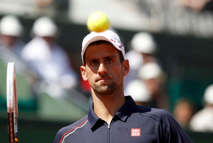 Srbský tenista Novak Djokovič sleduje míček v duelu se Slovincem Blazem Kavčičem ve 2. kole French Open 2012.