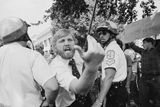 Muž provokuje Íránce demonstrující za Chomejního ve Washingtonu D.C. (1980).