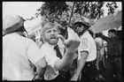 Muž provokuje Íránce demonstrující za Chomejního ve Washingtonu D.C. (1980).