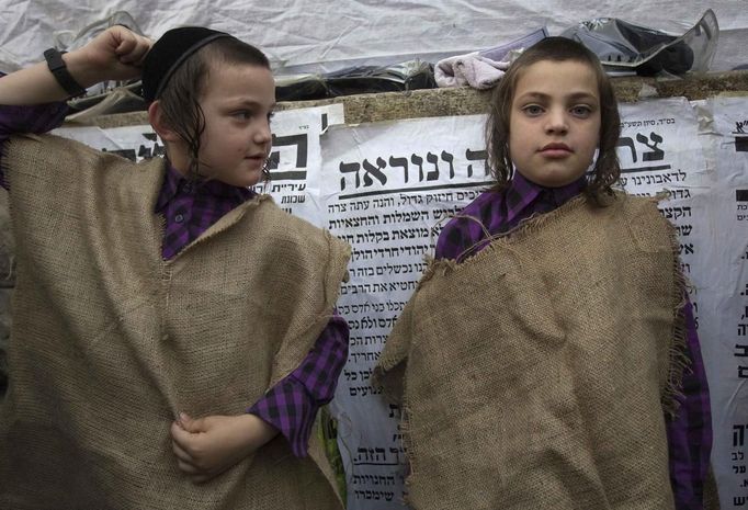 Ultra-Orthodox Jewish boys wear sacks, a symbol of mourning, during a protest against a new conscription law that might force ultra-Orthodox Jews to serve in the army, in Jerusalem's Mea Shearim neighbourhood June 25, 2012. Israel's Supreme Court ruled in February that the so-called "Tal Law", a 2002 measure that effectively shielded ultra-Orthodox communities from military service, was unconstitutional. The government, faced with the court's ruling, must now either revamp the law, which will expire in August, or approve new legislation. REUTERS/Ronen Zvulun (JERUSALEM - Tags: RELIGION MILITARY POLITICS CIVIL UNREST) Published: Čer. 25, 2012, 10:29 dop.