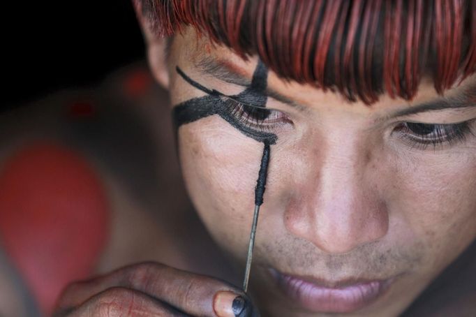 A Yawalapiti man paints his face to prepare for this year's 'quarup,' a ritual held over several days to honour in death a person of great importance to them, in the Xingu National Park, Mato Grosso State, August 15, 2012. This year the Yawalapiti tribe honoured two people - a Yawalapiti Indian who they consider a great leader, and Darcy Ribeiro, a well-known author, anthropologist and politician known for focusing on the relationship between native peoples and education in Brazil. Picture taken August 15, 2012. REUTERS/Ueslei Marcelino (BRAZIL - Tags: SOCIETY ENVIRONMENT) FOR EDITORIAL USE ONLY. NOT FOR SALE FOR MARKETING OR ADVERTISING CAMPAIGNS. ATTENTION EDITORS - PICTURE 14 OF 37 FOR THE PACKAGE 'THE YAWALAPITI QUARUP RITUAL' Published: Srp. 29, 2012, 10:20 dop.